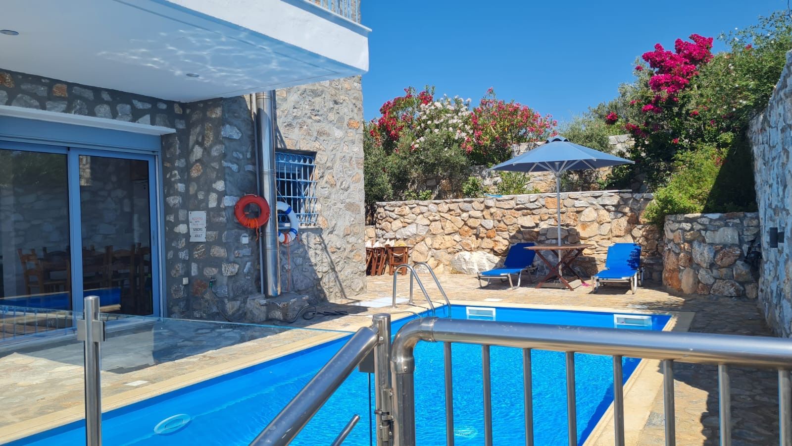 Pool terrace with sun loungers and bougainvillea