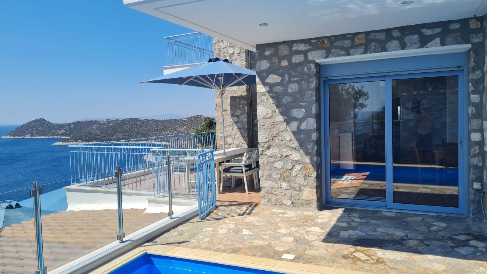 Pool and shaded terrace above the Aegean